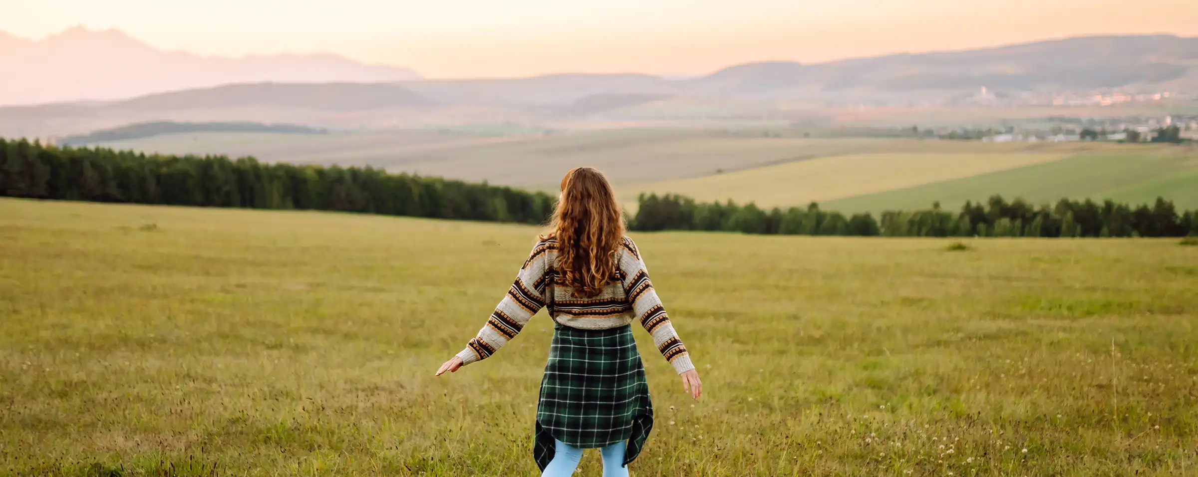 young woman looking over valley and seeing clearly after vision correction surgery
